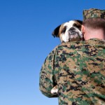A military man hugs his dog